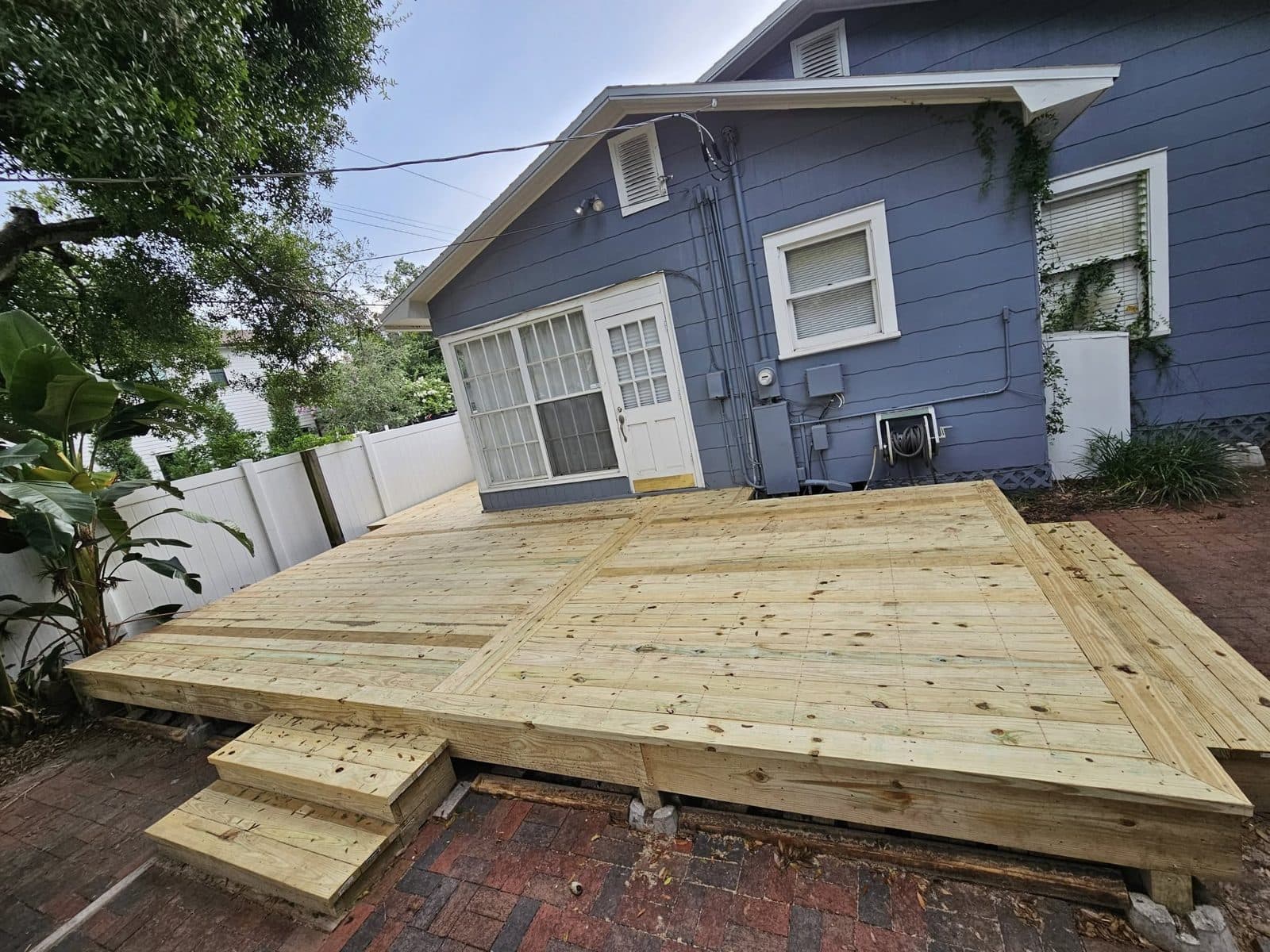Completed backyard deck over a paver patio built by True Carpenters