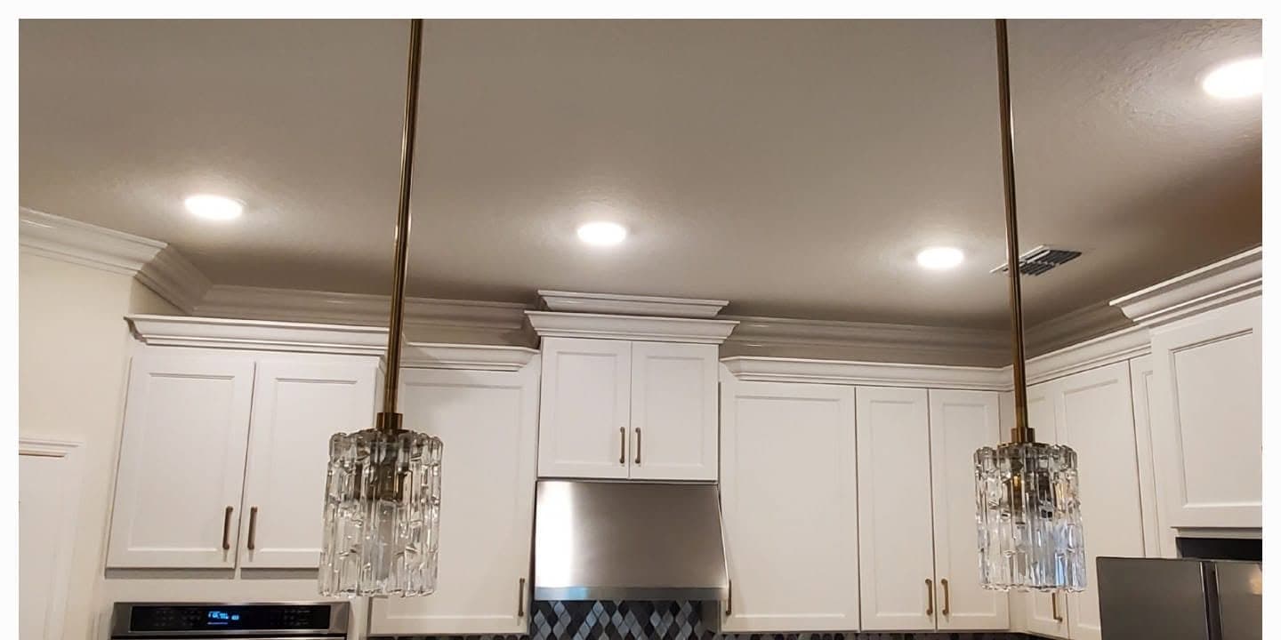 White kitchen cabinetry with crown molding installed by True Carpenters